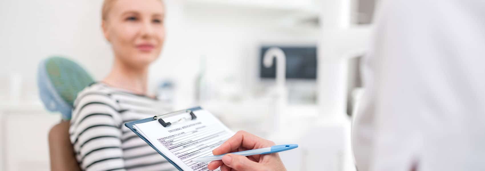 Dentist writing the patient form